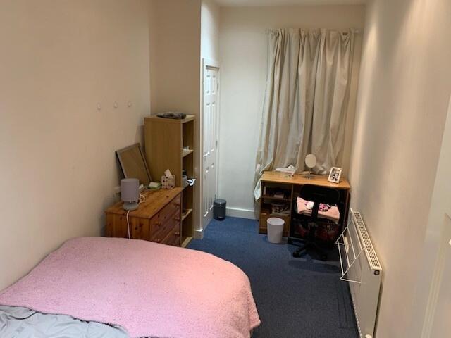 Cozy bedroom with a single bed, desk area and w...