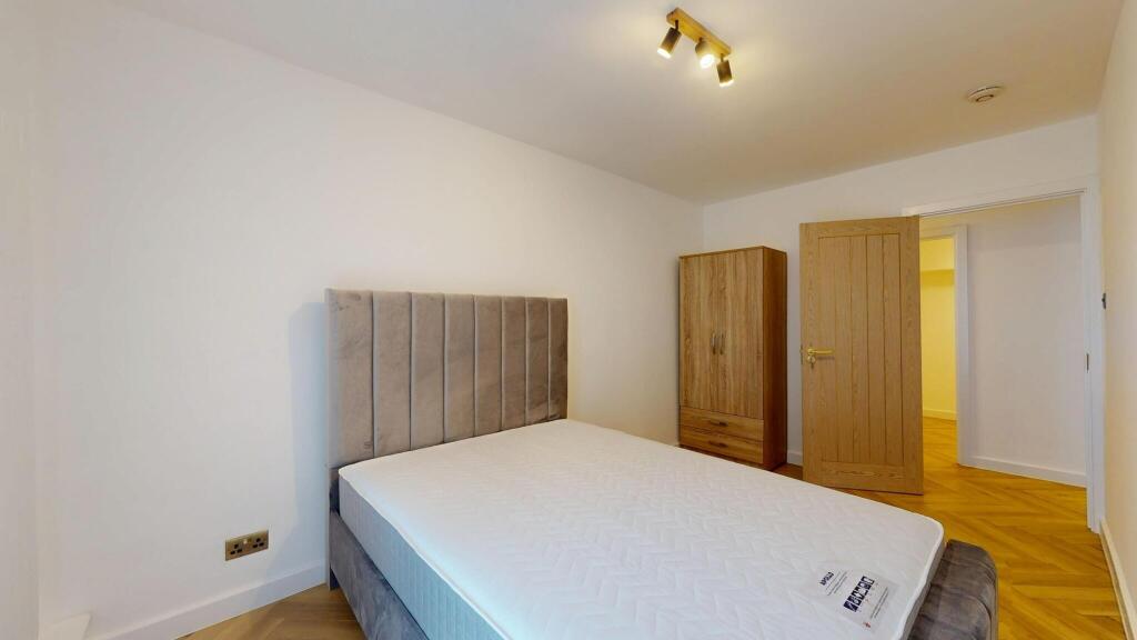 A modern double bedroom featuring a plush grey ...