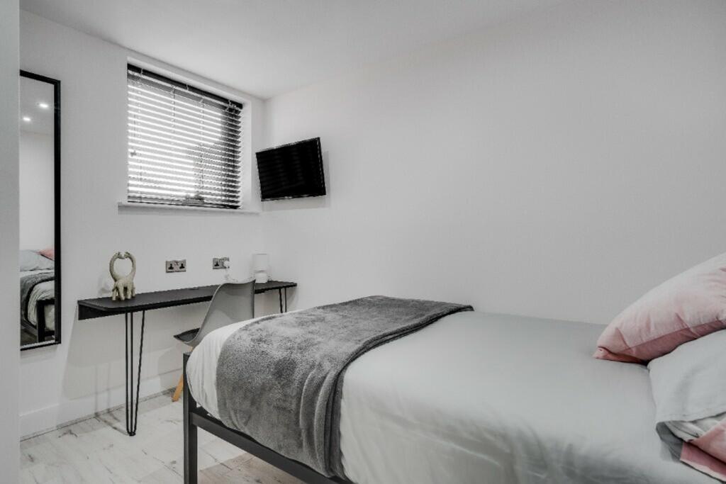 A bright and tidy double bedroom featuring a wo...