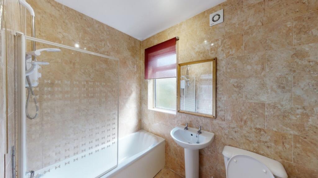 A spacious and modern bathroom featuring a bath...