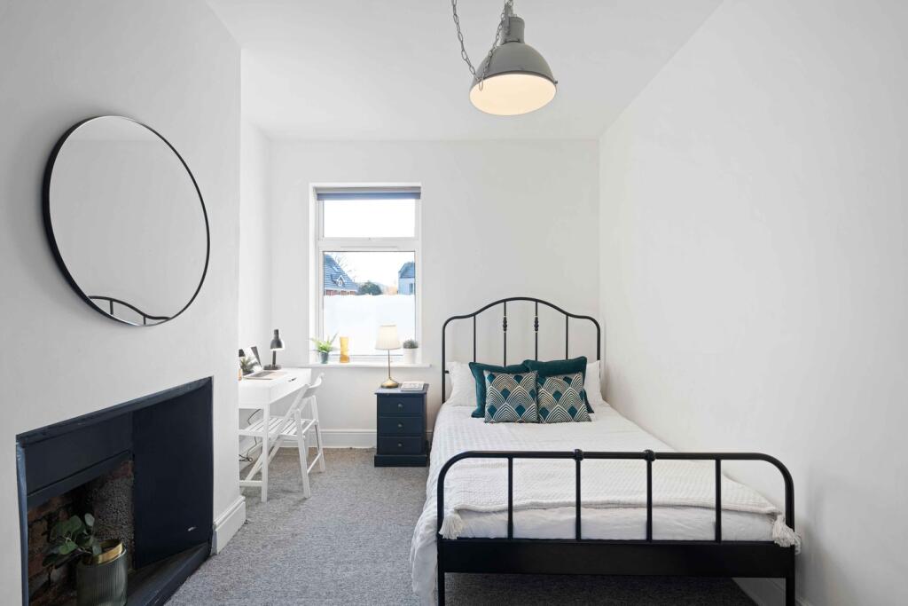 A bright and inviting double bedroom featuring ...