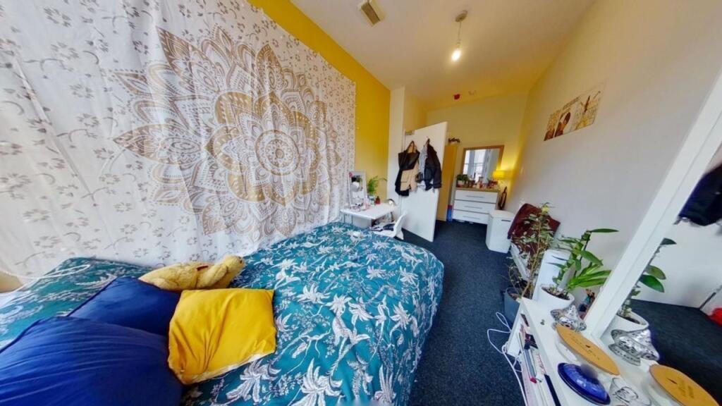 A cozy and colorful single bedroom featuring a ...