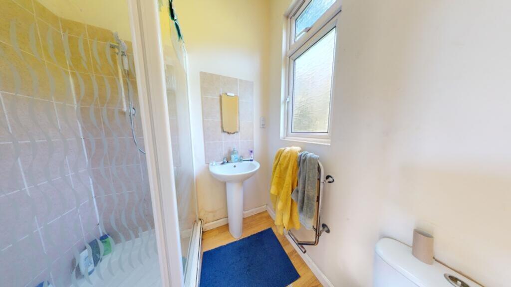 A bright and tidy bathroom featuring a shower a...