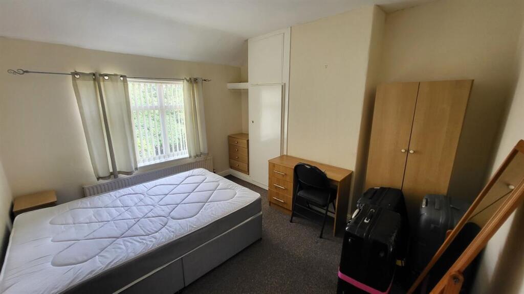A bright and tidy double bedroom featuring a co...