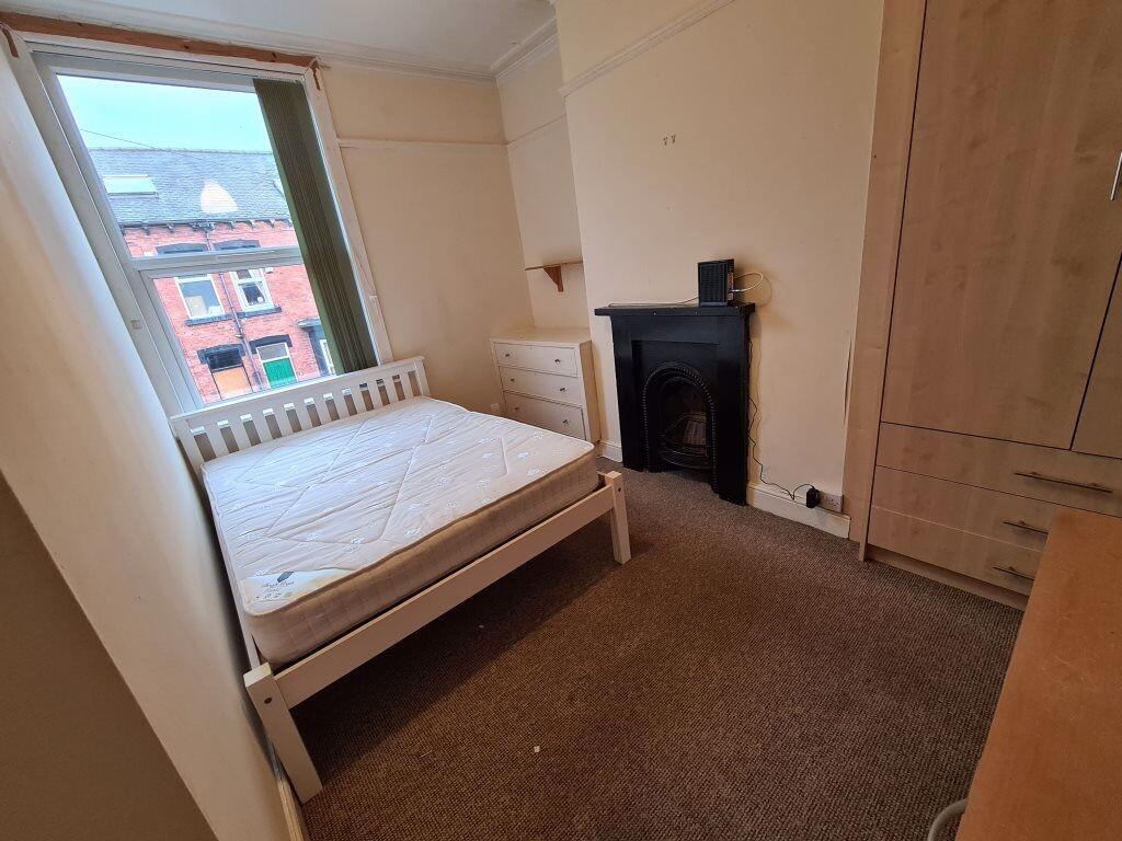 A cozy single bedroom with a white bed frame an...