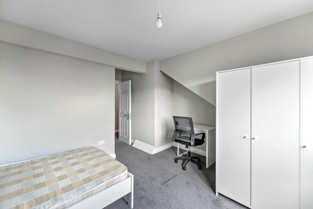 Bright and tidy bedroom featuring a comfortable...