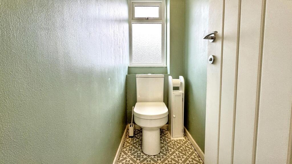 A bright and clean single toilet room featuring...