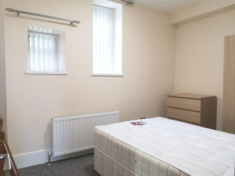 A neat and simple bedroom featuring a comfortab...