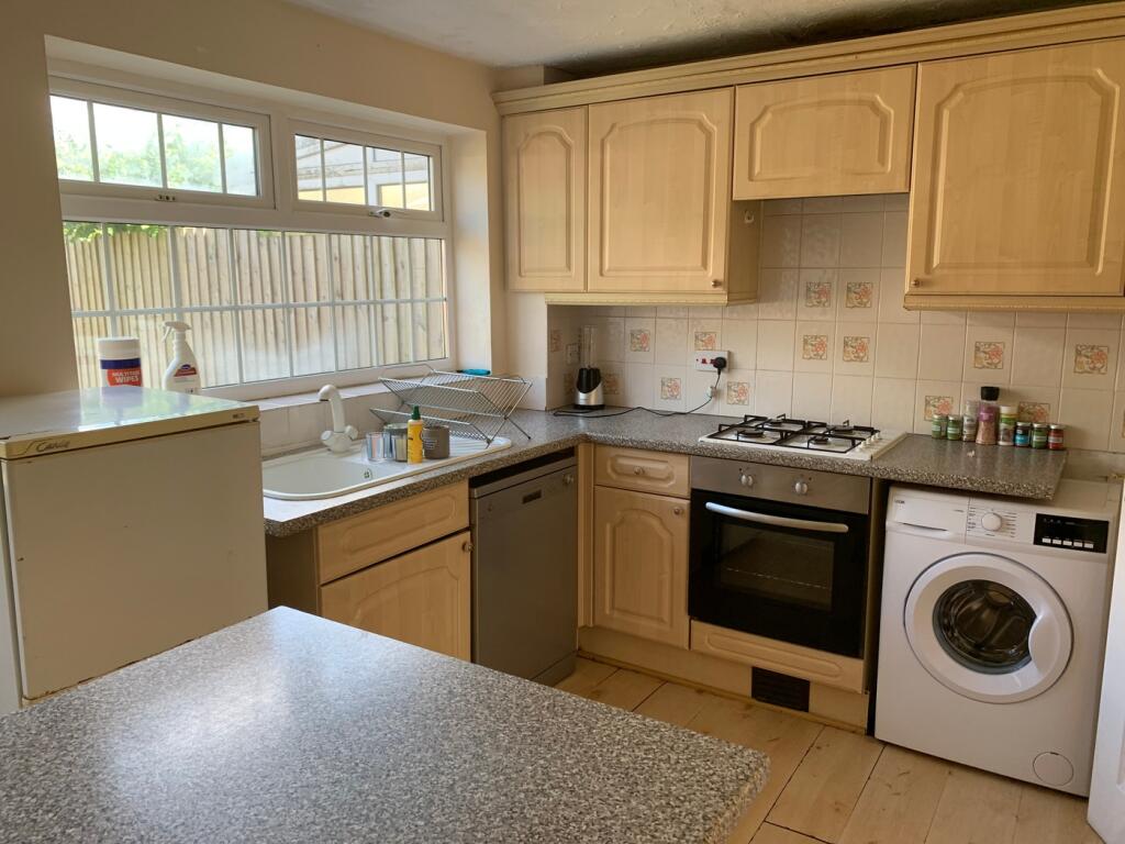 A bright and tidy kitchen with ample storage an...