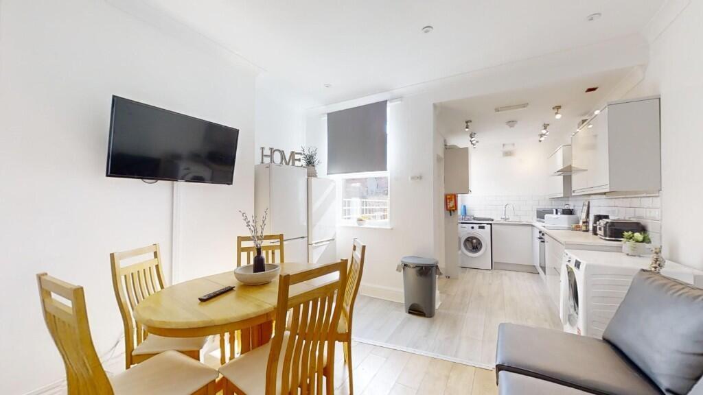 Bright and modern kitchen and dining area featu...