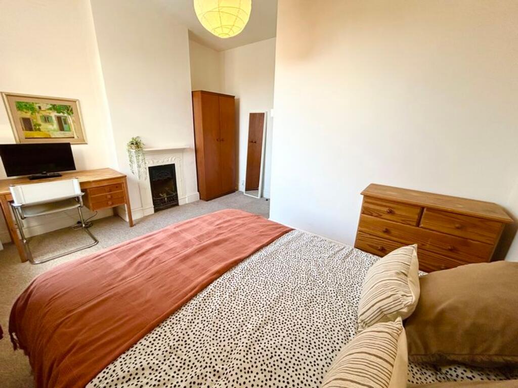Spacious double bedroom featuring a cozy ambian...