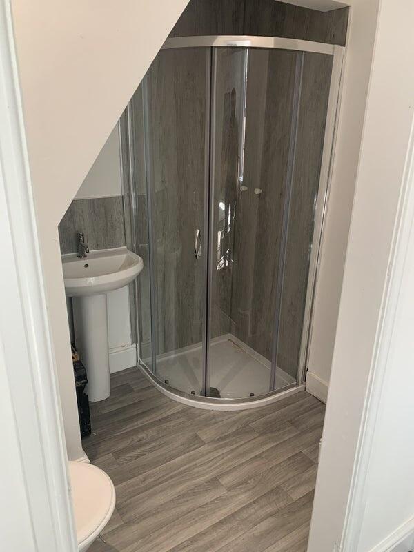 Modern bathroom featuring a corner shower enclo...