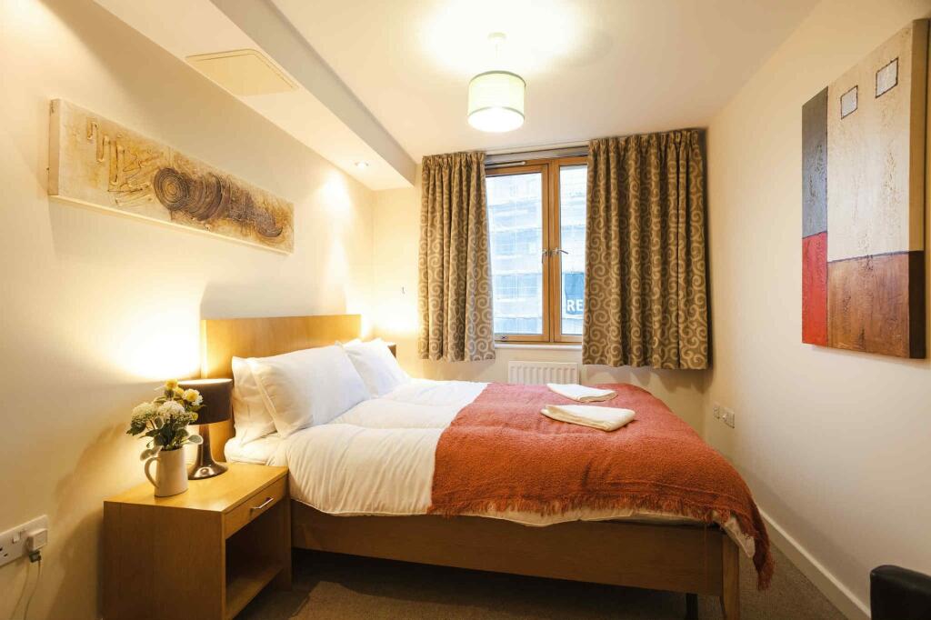 A cozy and well-kept double bedroom featuring a...