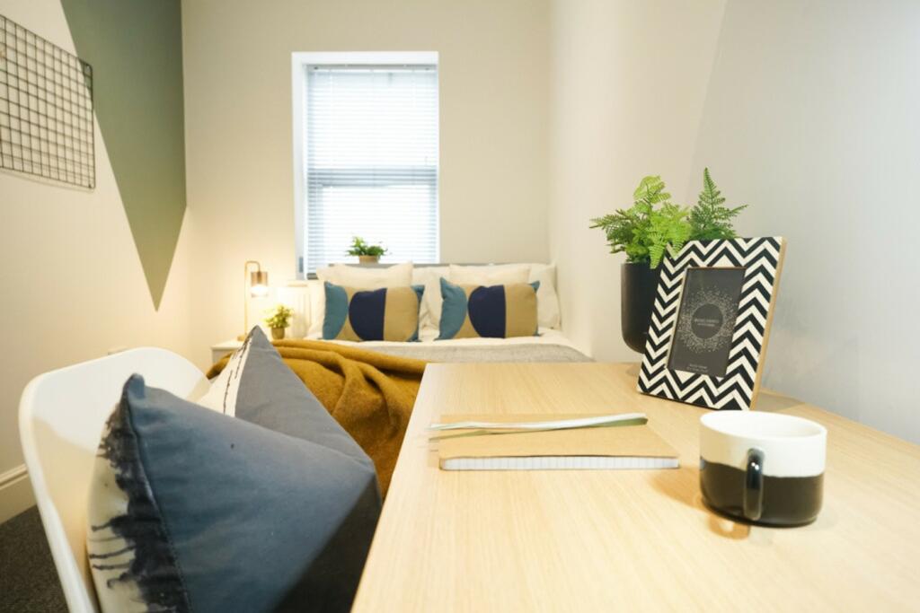 A bright and inviting double bedroom with styli...