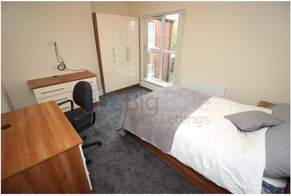 A well-kept single bedroom featuring a comforta...