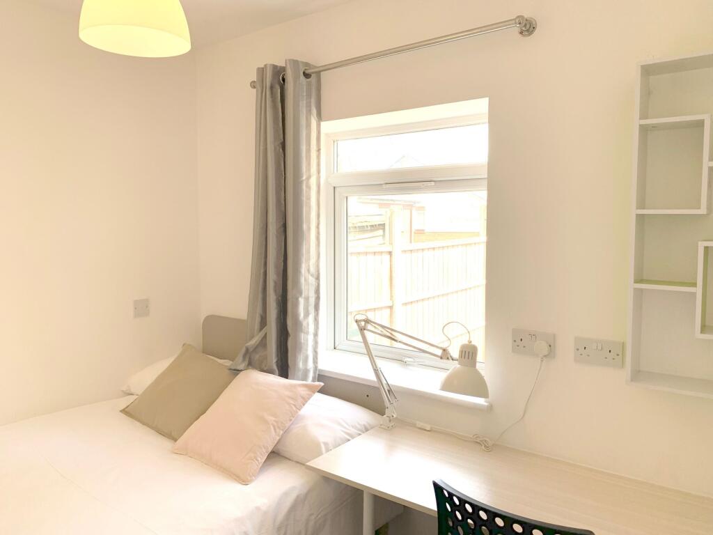 A bright and tidy single bedroom featuring a ne...