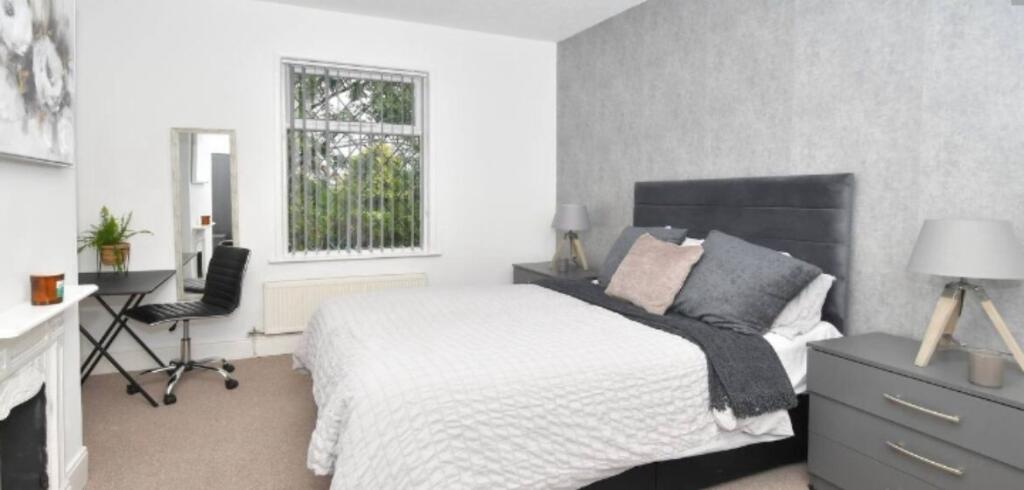 A stylish and modern bedroom featuring a large ...