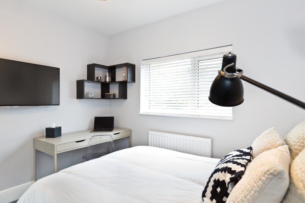 A bright and modern bedroom featuring a comfort...