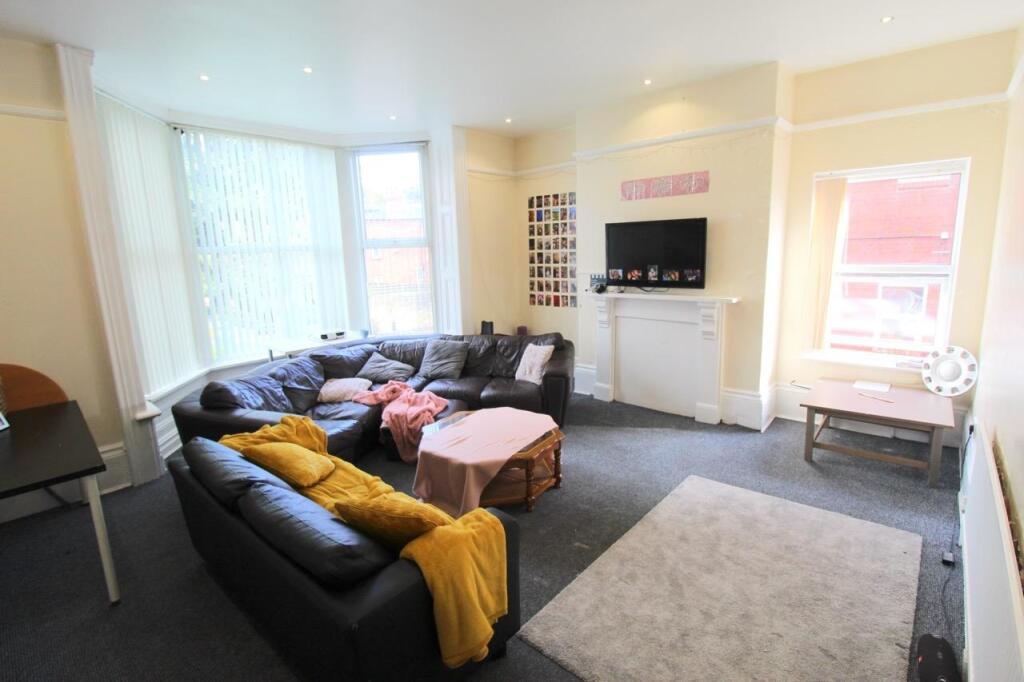 Bright, welcoming communal living room with lar...