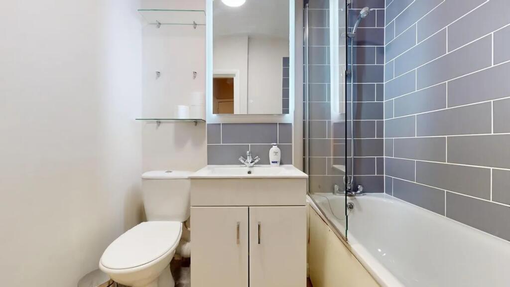 A modern bathroom suite featuring a clean white...