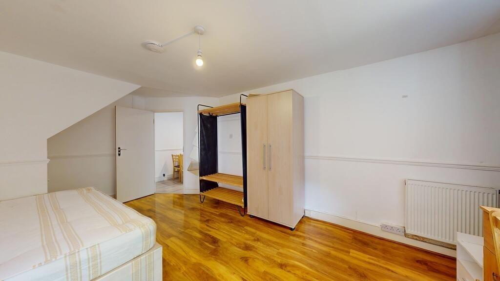 A spacious and bright bedroom featuring a comfo...