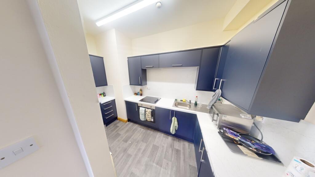 A modern kitchen with dark blue cabinetry and w...