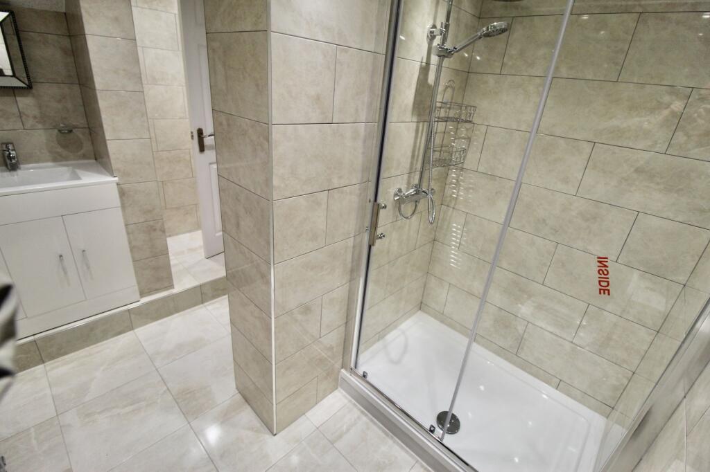 Modern bathroom featuring a spacious shower wit...
