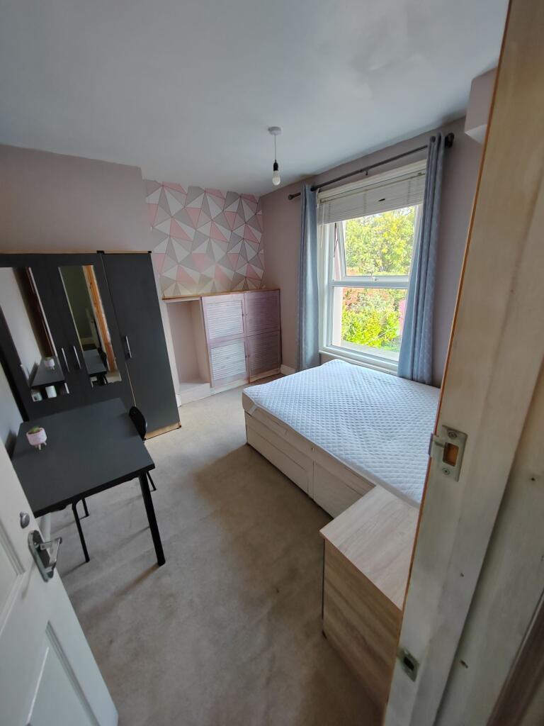 Bright and welcoming bedroom with a large windo...