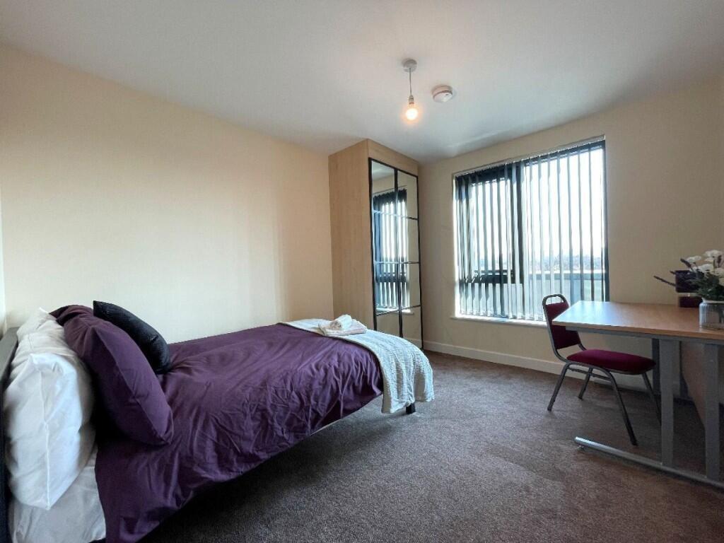 A cozy single bedroom featuring a comfortable b...