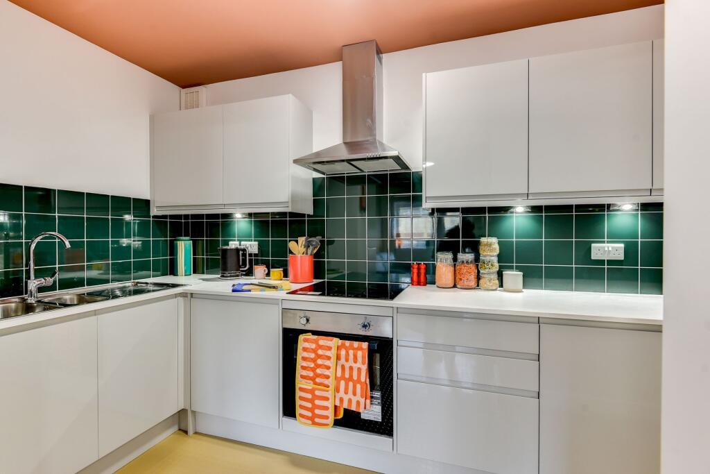 This modern kitchen features sleek cabinetry, a...