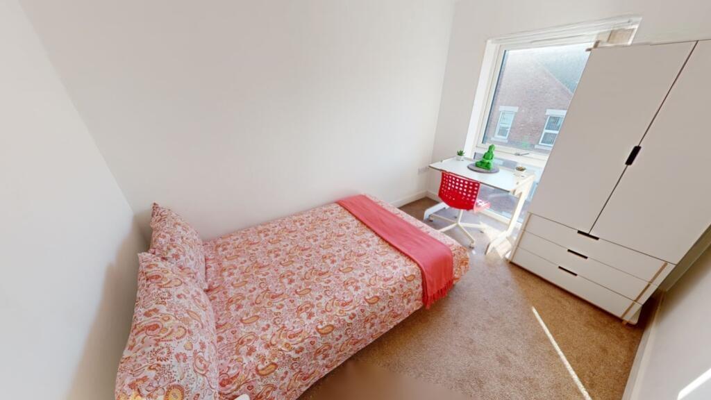 A bright and tidy single bedroom featuring a co...