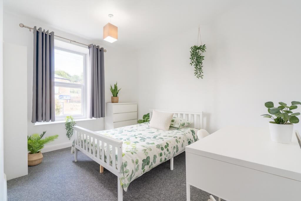 Bright and inviting bedroom featuring a fresh, ...