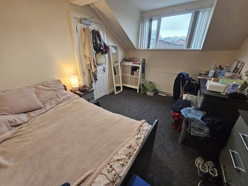 A cozy bedroom featuring a double bed, a study ...