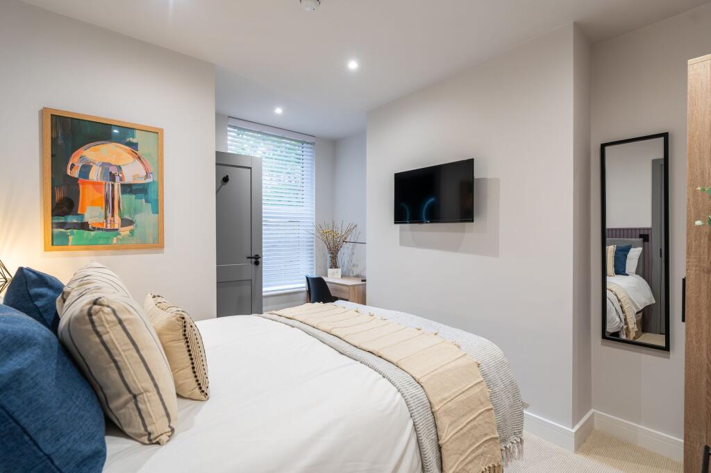 Bright and stylish master bedroom featuring a c...