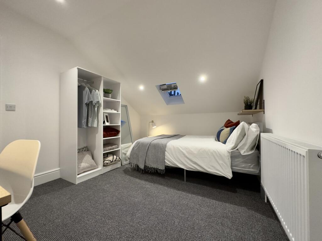 A bright and tidy double bedroom featuring a st...
