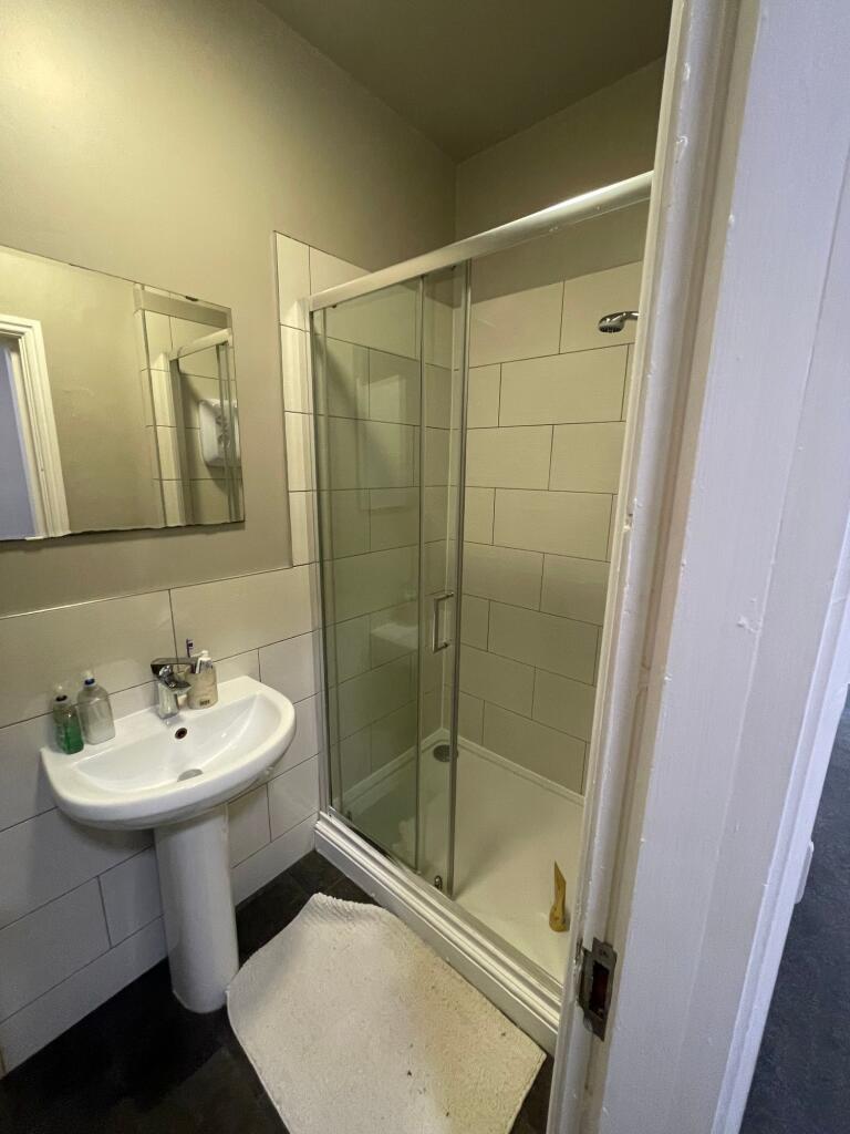 A modern bathroom featuring a glass-enclosed sh...