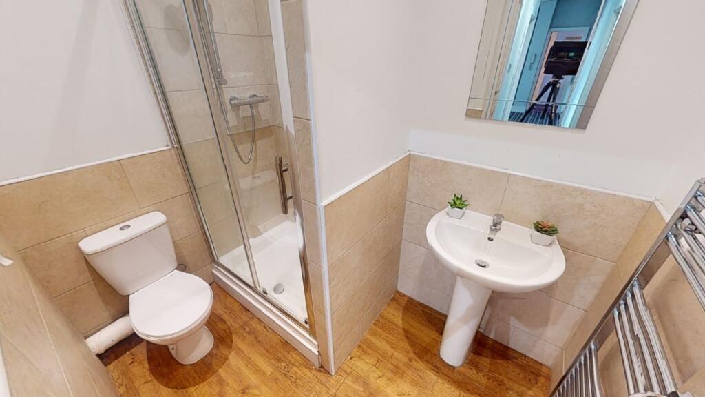 A bright and clean bathroom suite featuring a m...