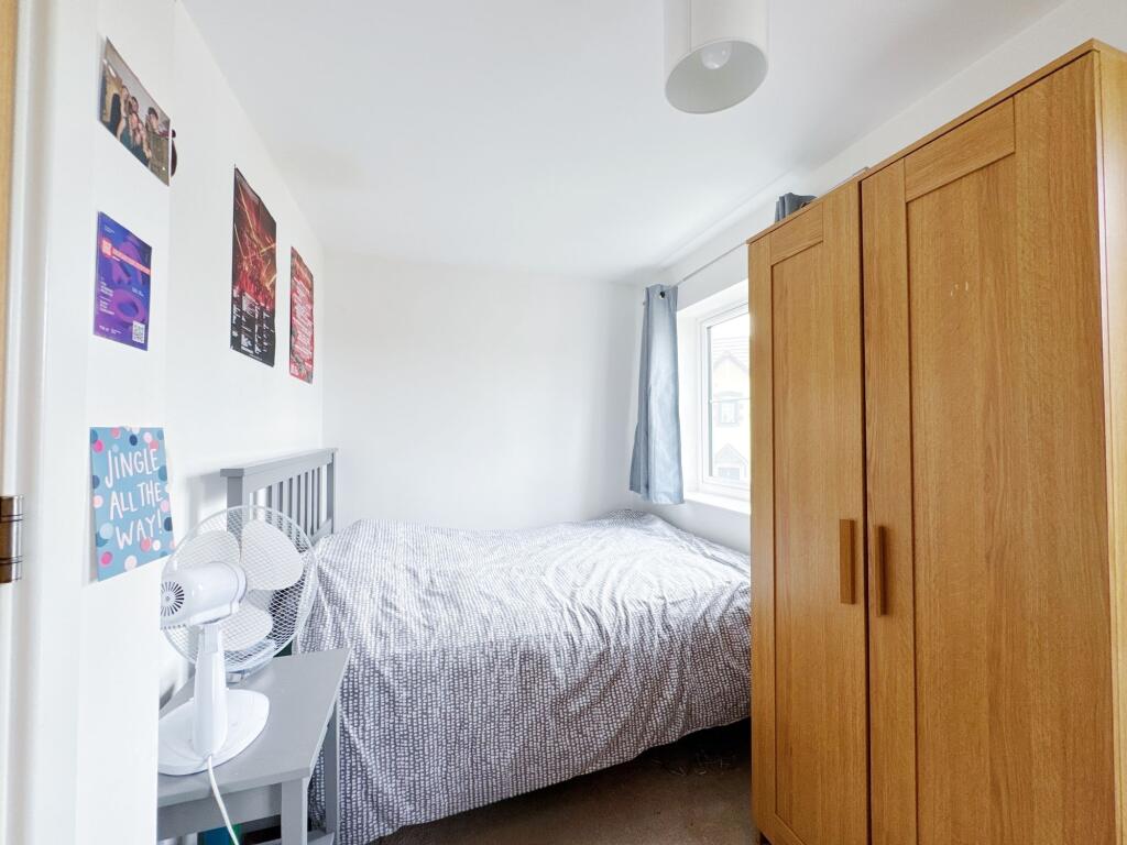 A bright, neatly maintained bedroom featuring a...