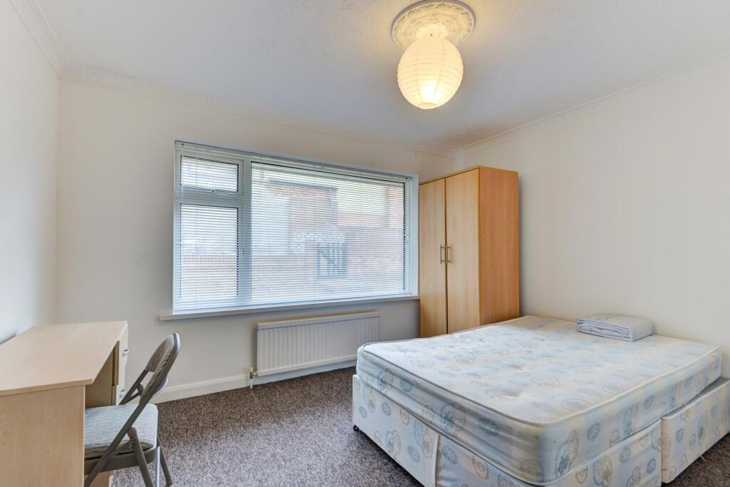 A bright and tidy double bedroom featuring a la...