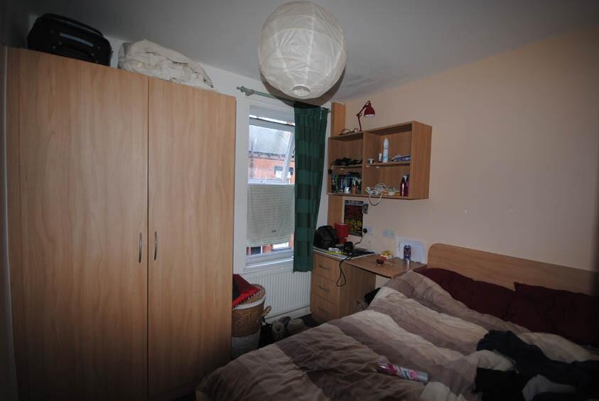 A cozy bedroom with a double bed, wooden wardro...