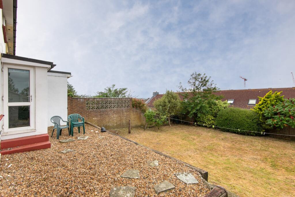 A well-maintained garden featuring a gravel pat...