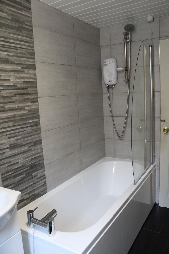 Modern bathroom featuring a large bathtub, a sh...