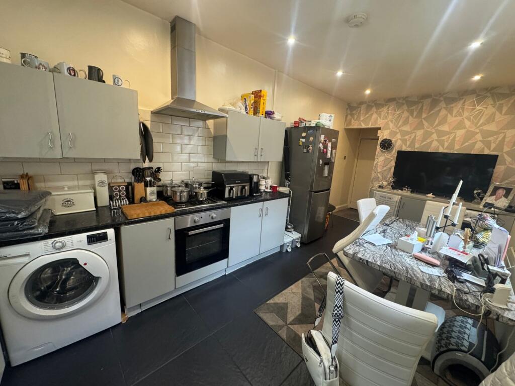 Modern kitchen featuring integrated appliances,...