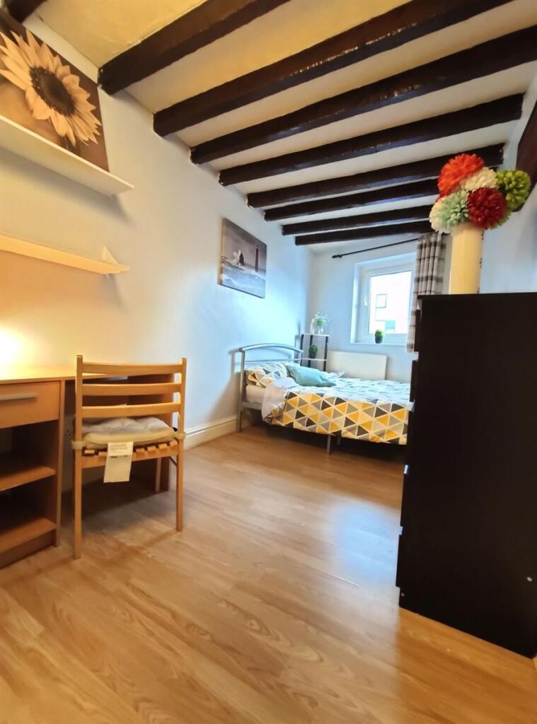 Cozy single bedroom featuring wooden flooring, ...