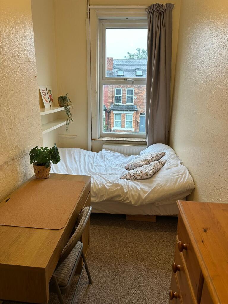 A cozy student bedroom filled with natural dayl...