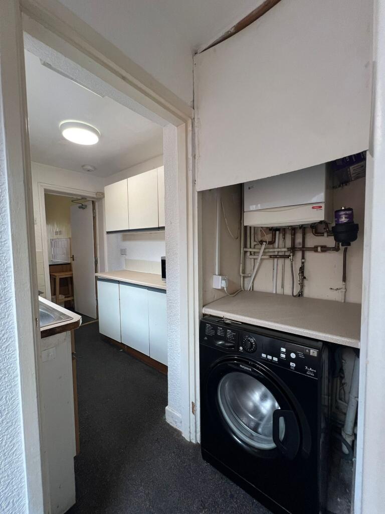 Compact kitchen featuring essential appliances ...