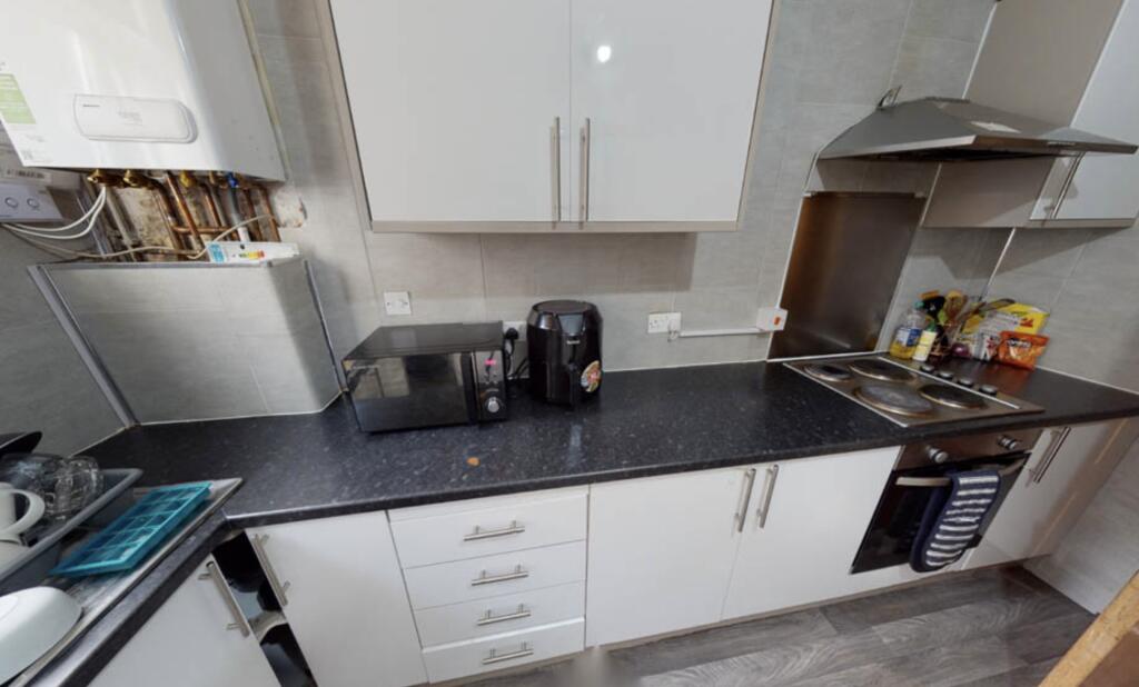 A modern kitchen area featuring a sleek black c...