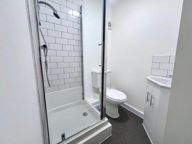 A modern bathroom featuring a clean, tiled show...