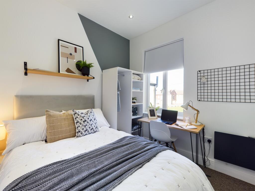 A bright and stylish double bedroom featuring a...