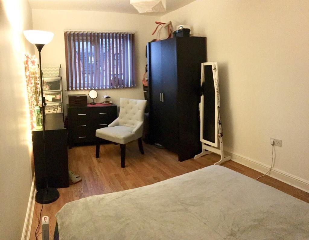 A cozy double bedroom featuring warm wooden flo...